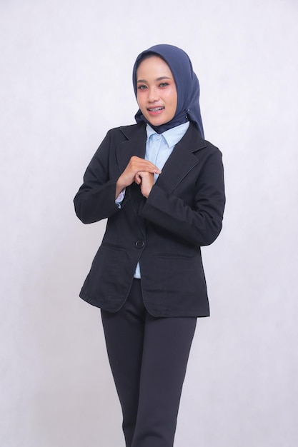 Porträt einer indonesischen reifen blauen Hemd-Bürofrau, die einen Hijab trägt und in rechten Winkeln steht.