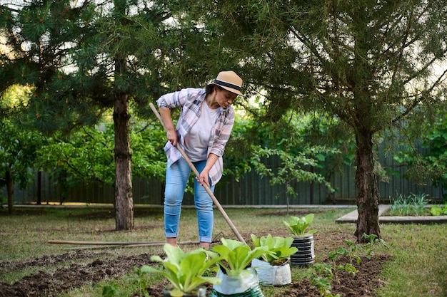 Porträt einer inspirierten Bäuerin Gärtnerin, die während der Gartenarbeit im Bio-Bauernhof Erde gräbt Gartenkonzept