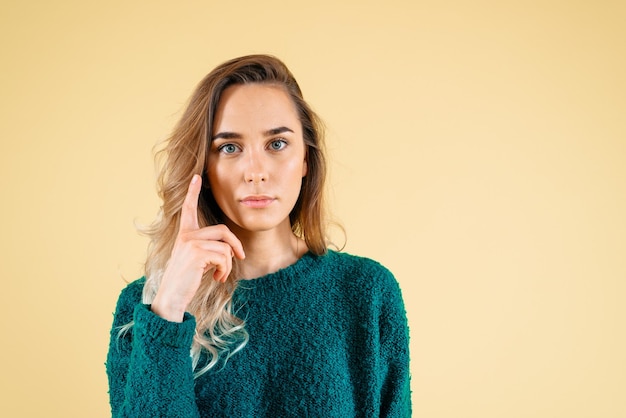 Porträt einer isolierten hübschen Frau mit Fingerzeichen haben eine Idee auf gelbem Hintergrund