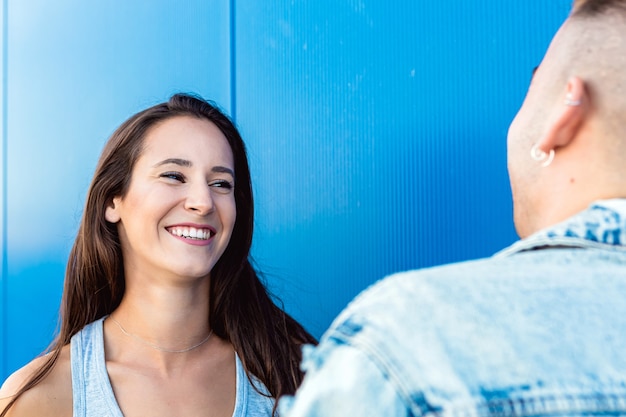 Porträt einer isolierten schönen jungen Frau, die zu ihrem Freund in Blau lächelt