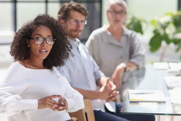 Porträt einer jungen afroamerikanischen Frau im Büro am Tisch