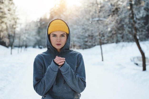 Porträt einer jungen athletischen Frau, die Sportkleidung trägt und bereit für ein Wintertraining ist