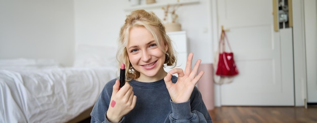 Porträt einer jungen blonden Content-Schöpferin, die ein Video für soziale Medien über Make-up aufnimmt