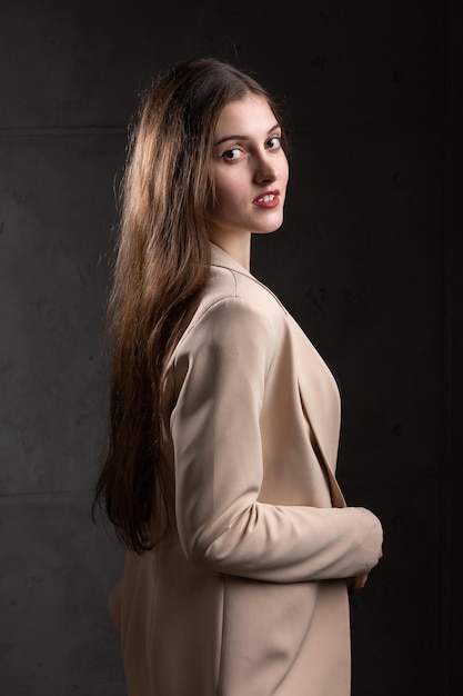 Porträt einer jungen Brünette mit langen Haaren im Studio Dramatisches Foto in dunklen Farben