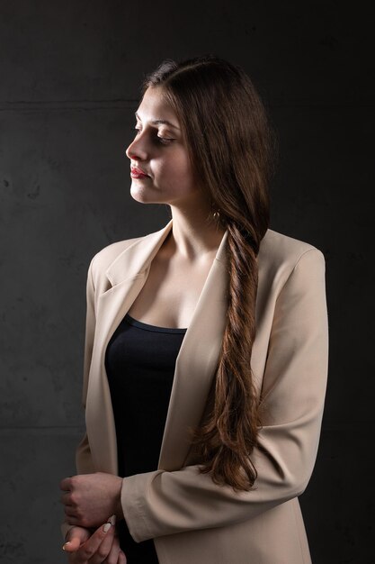 Porträt einer jungen Brünette mit langen Haaren im Studio Dramatisches Foto in dunklen Farben