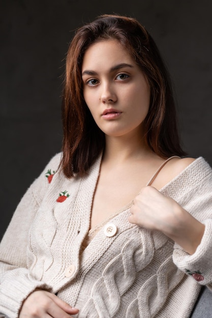 Porträt einer jungen Brünette mit langen Haaren im Studio Dramatisches Foto in dunklen Farben