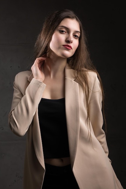 Porträt einer jungen Brünette mit langen Haaren im Studio Dramatisches Foto in dunklen Farben