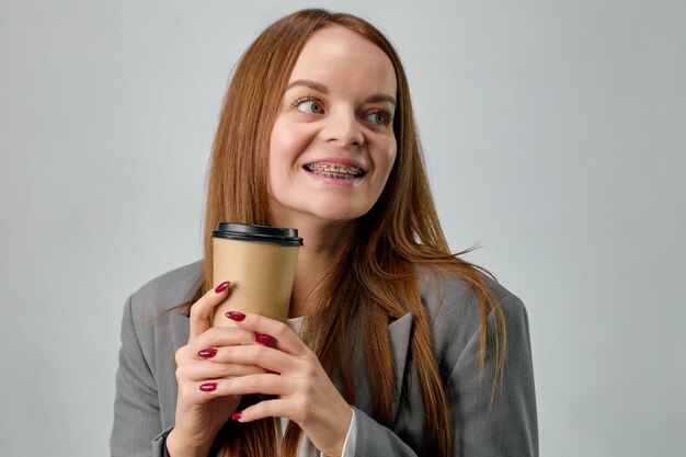 Porträt einer jungen europäischen Frau mit Zahnspangen, die Kaffee trinkt