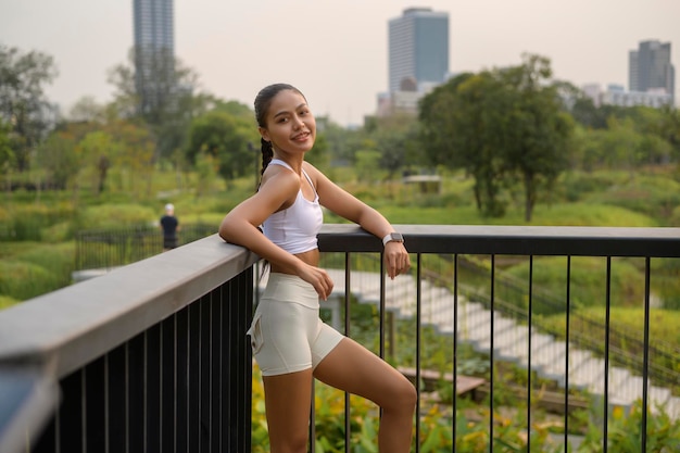 Porträt einer jungen Fitnessfrau in Sportbekleidung im Stadtpark Gesund und Lebensstil