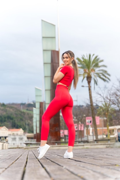 Porträt einer jungen fitten Frau in roter Kleidung beim Sport in der Stadt im Frühjahr Fitness