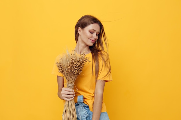 Porträt einer jungen Frau, Blumenstrauß aus getrockneten Blumen, Freizeitkleidung, Lächeln, die isolierten Hintergrund aufwirft