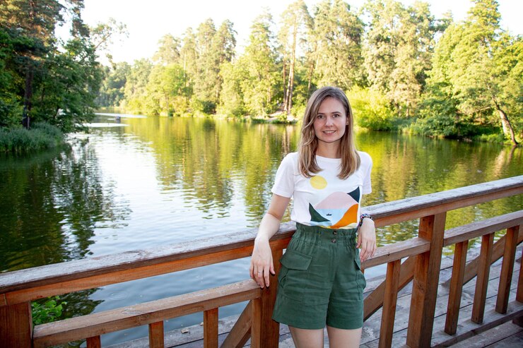 Foto porträt einer jungen frau, die am geländer gegen den see steht