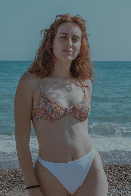 Porträt einer jungen Frau, die am Strand steht