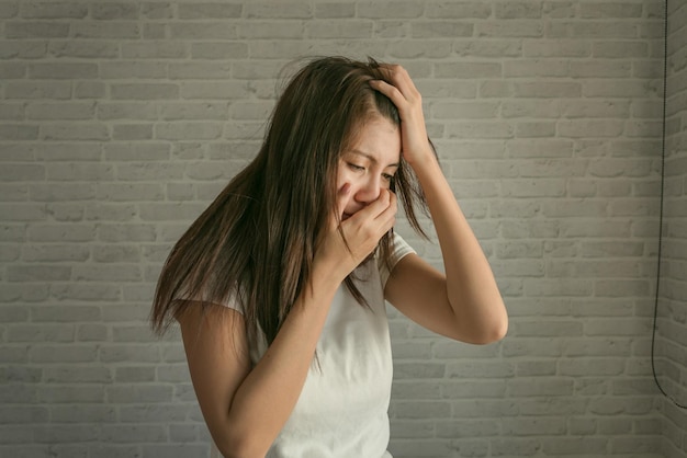 Porträt einer jungen Frau, die an der Wand steht