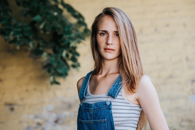 Porträt einer jungen Frau, die an der Wand steht