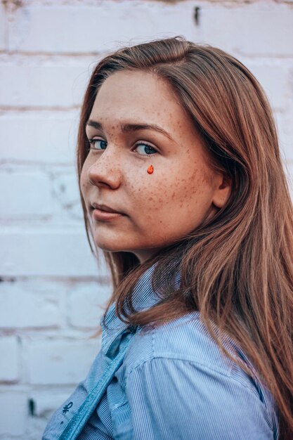 Foto porträt einer jungen frau, die an der wand steht