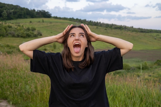 Foto porträt einer jungen frau, die auf dem feld gegen den himmel steht