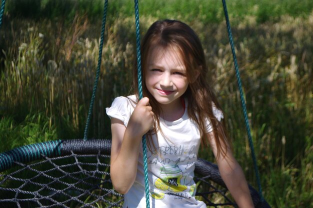 Foto porträt einer jungen frau, die auf dem feld sitzt