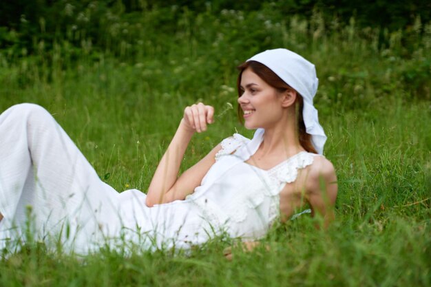 Foto porträt einer jungen frau, die auf dem gras sitzt