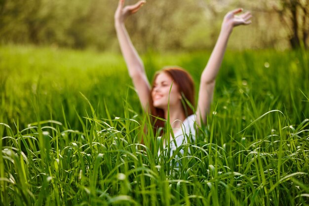 Porträt einer jungen Frau, die auf einem grasbewachsenen Feld sitzt