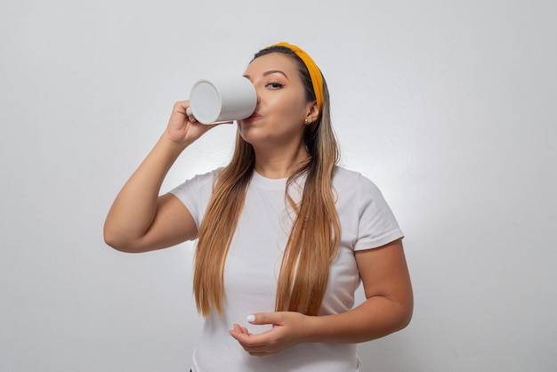 Porträt einer jungen Frau, die aus einer Tasse trinkt