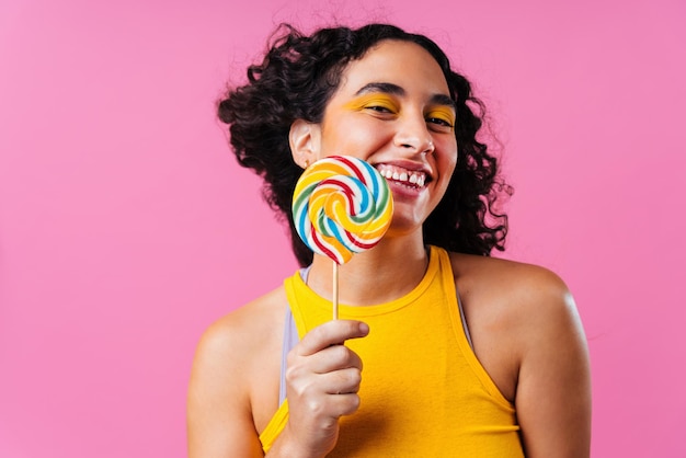 Porträt einer jungen Frau, die einen Lolli gegen einen Korallengrund hält