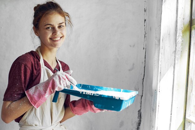 Foto porträt einer jungen frau, die gegen die wand steht und ein handy benutzt