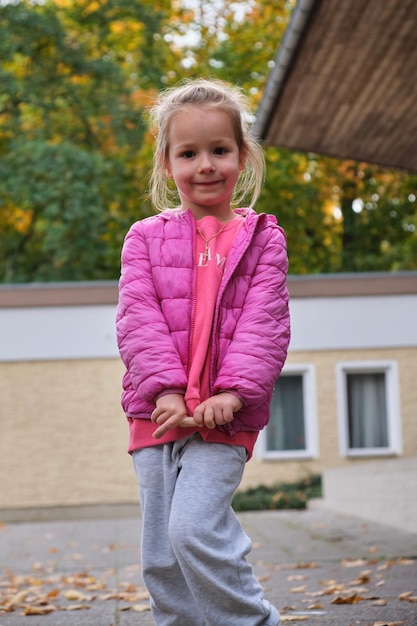 Porträt einer jungen Frau, die gegen ein Gebäude steht.