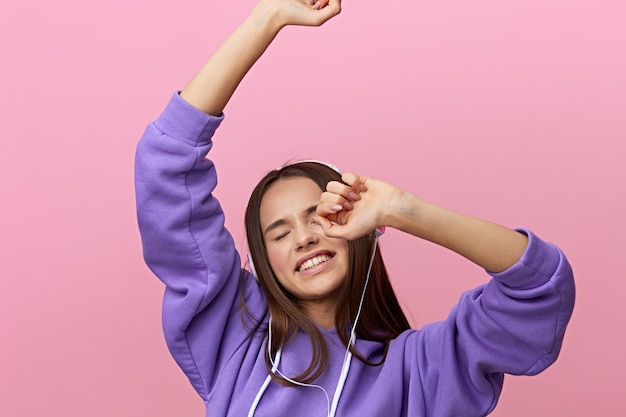 Porträt einer jungen Frau, die gegen einen rosa Hintergrund gestimmt