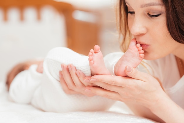 Porträt einer jungen Frau, die ihre kleine Babytochter küsst