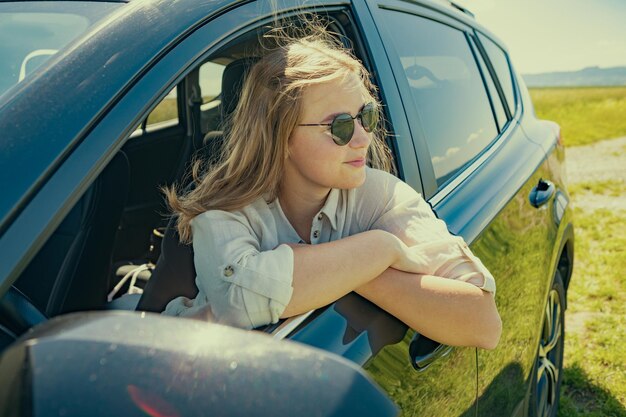 Foto porträt einer jungen frau, die in einem auto sitzt