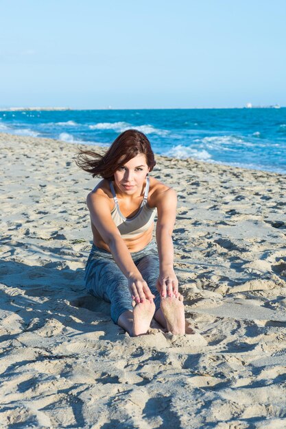 Foto porträt einer jungen frau, die sich am strand ausstreckt