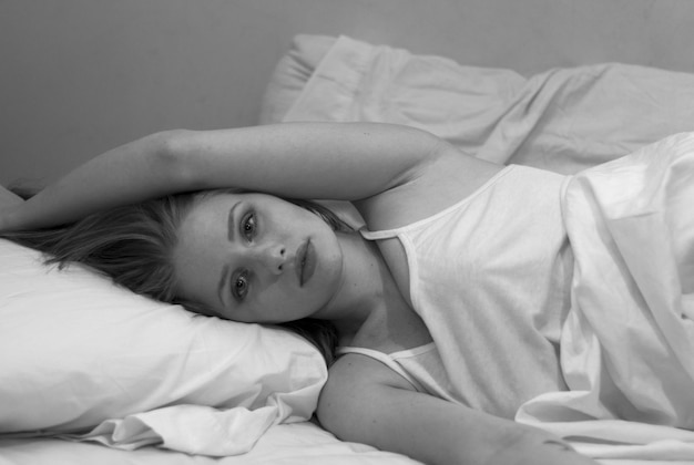 Porträt einer jungen Frau, die sich im Bett entspannt