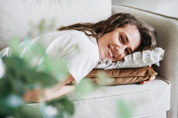 Foto porträt einer jungen frau, die sich zu hause auf dem sofa ausruht