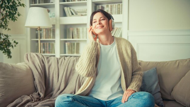 Porträt einer jungen Frau, die sich zu Hause entspannt und Musik hört