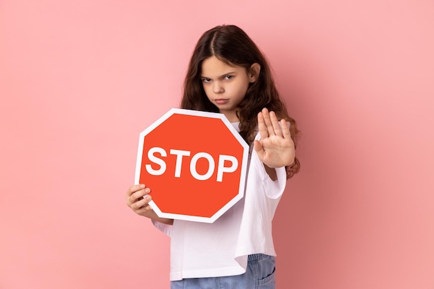 Foto porträt einer jungen frau, die vor einem rosa hintergrund steht