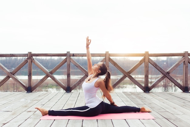 Porträt einer jungen Frau, die Yoga im Freien auf der Natur praktiziert