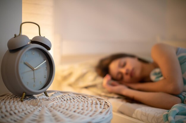 Foto porträt einer jungen frau, die zu hause auf dem bett sitzt