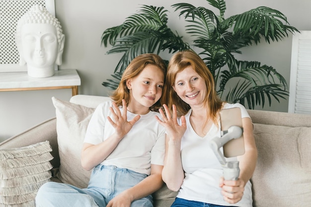 Foto porträt einer jungen frau, die zu hause auf dem sofa sitzt