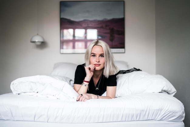 Porträt einer jungen Frau, die zu Hause im Bett liegt