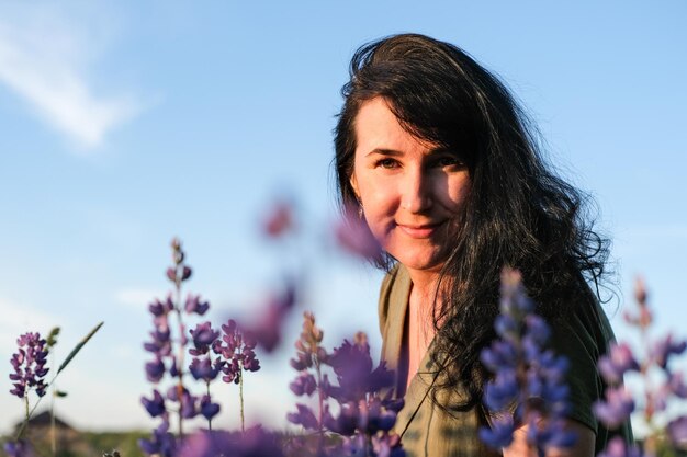 Porträt einer jungen Frau im Sommerlebensstil mit lila Blumen