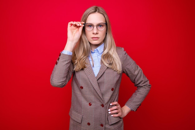 Porträt einer jungen Frau in Businesskleidung auf rotem Grund