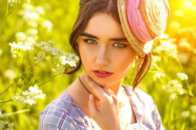 Porträt einer jungen Frau in einem Hut auf dem Gras