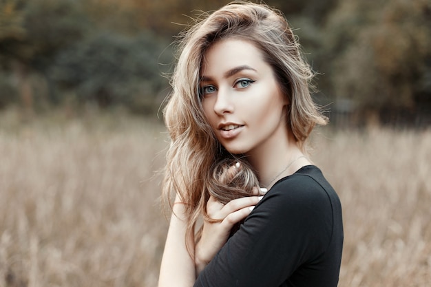 Porträt einer jungen Frau in einem schwarzen Hemd auf der Natur