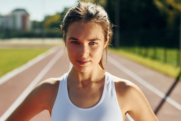 Foto porträt einer jungen frau in sportlicher kleidung, die im freien trainiert