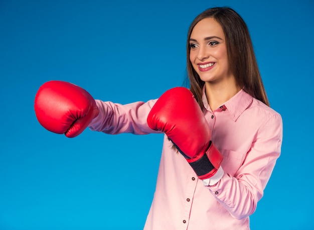 Porträt einer jungen Frau mit Boxhandschuh.