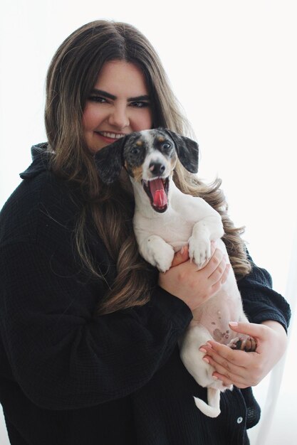 Porträt einer jungen Frau mit einem Hund auf weißem Hintergrund