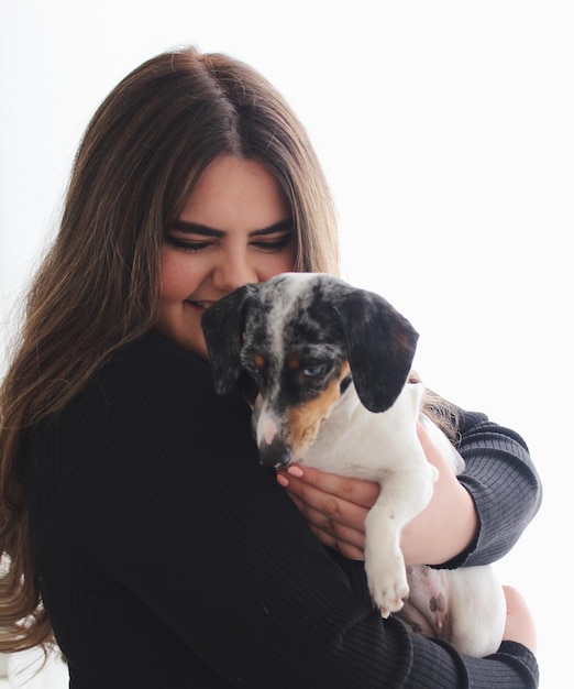 Porträt einer jungen Frau mit einem Hund auf weißem Hintergrund