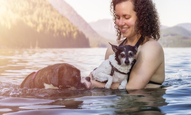 Porträt einer jungen Frau mit einem Hund im Wasser