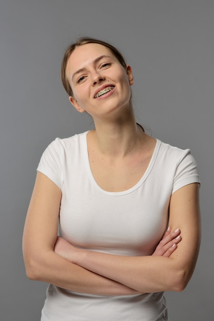 Porträt einer jungen Frau mit Hosenträgern in einem weißen T-Shirt